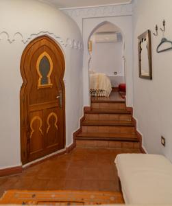 a room with a wooden door and stairs at Casa Sabila in Chefchaouen
