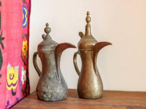 two metal vases sitting on a wooden table at Pass the Keys Exotic Jesmond Gem in Newcastle upon Tyne