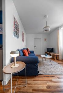 uma sala de estar com um sofá azul e uma mesa em Résidence Léon Blum - Appartements design - Parking em Clermont-Ferrand