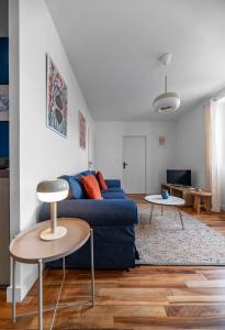 a living room with a blue couch and a table at Résidence Léon Blum - Appartements design - Parking in Clermont-Ferrand