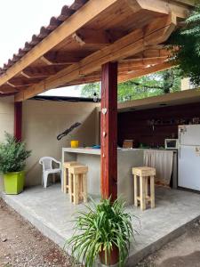 a patio with a counter and tables and a kitchen at Hostel Avetaia in Santa Rosa de Calamuchita