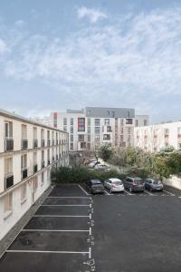 un aparcamiento con coches estacionados frente a los edificios en Résidence Léon Blum - Appartements design - Parking en Clermont-Ferrand