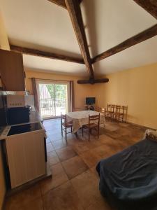 Il comprend une cuisine et un salon avec une table et des chaises. dans l'établissement Le Hameau de cure, à Cazouls-lès-Béziers