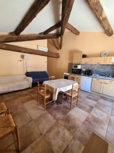 - une cuisine et une salle à manger avec une table et des chaises dans l'établissement Le Hameau de cure, à Cazouls-lès-Béziers