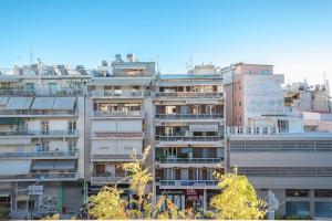 um edifício de apartamentos alto com muitas janelas em Luxurius Apt in Megaro Mousikis metro station em Atenas