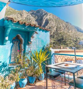 a blue house with a table and chairs on a balcony at Casa Sabila in Chefchaouen