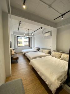 a room with four beds and a couch and a room with at One Day 有日-民生路一段207號 in Tainan