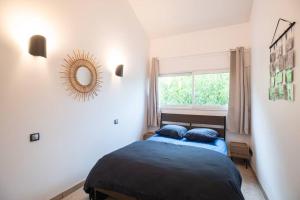 Schlafzimmer mit einem Bett und einem Wandspiegel in der Unterkunft Le Chill House centre ville in Bourg-en-Bresse