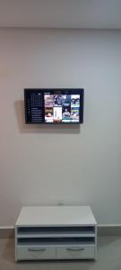 una TV a schermo piatto su una parete bianca di RECANTO BRENDA - Casa Luxo Capitólio com Vista pro lago, Escarpas e MorroChapeu a Capitólio