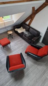 - un salon avec deux chaises et un canapé dans l'établissement Gite La Passerelle, à Ostheim