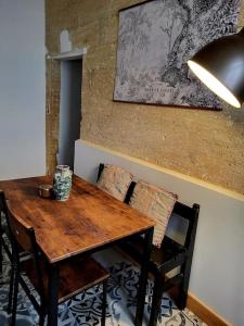 een houten tafel met twee stoelen en een tafel en een lamp bij T2 Duplex "Chez Évelyne" in Remoulins