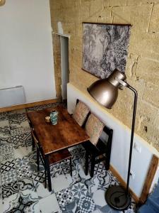 une chambre avec une table et une lampe à côté d'un mur dans l'établissement T2 Duplex "Chez Évelyne", à Remoulins