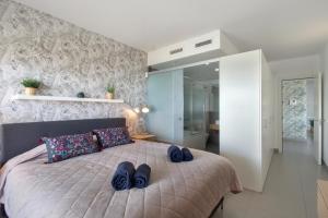 um quarto com uma cama com sapatos azuis em Luxury Apartment With Sea View em Benalmádena