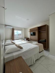 a large bedroom with two beds and a television at Hotel Carvalho in Ibiapina