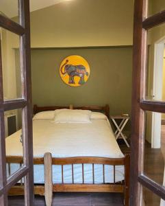 1 dormitorio con 1 cama con una foto en la pared en Hostel Avetaia en Santa Rosa de Calamuchita
