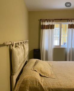 a bedroom with a bed and a window at Hostel Avetaia in Santa Rosa de Calamuchita