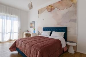 サレルノにあるCas’ A Mare - Beachfront Luxury Suitesのベッドルーム1室(大型ベッド1台、青いヘッドボード付)