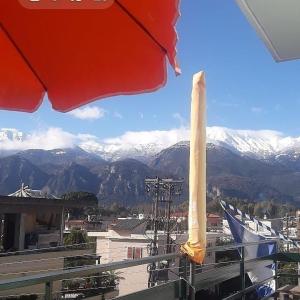 an umbrella on a balcony with a view of mountains at HELLAS PALACE ROOMS balcony in Sparti