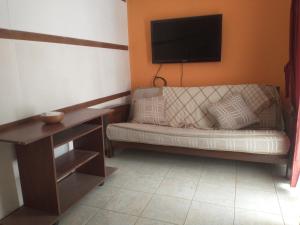 Departamento centro Boj في Deán Funes: غرفة معيشة مع أريكة وتلفزيون
