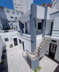 een wit gebouw met een trap aan de zijkant bij Nuevo Hotel Tivoli in Mar del Plata