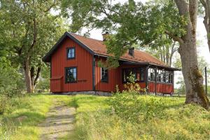 a red house in a field with trees at Siggesta Gård in Värmdö