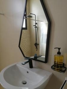 un lavandino da bagno con un grande specchio sopra di Lovely Studio a Ras al Khaimah