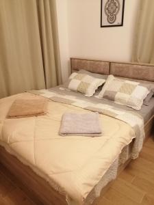 1 cama grande con 2 toallas encima en Lovely Studio, en Ras al Khaimah