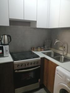 a kitchen with a stove top oven next to a sink at Lovely Studio in Ras al Khaimah