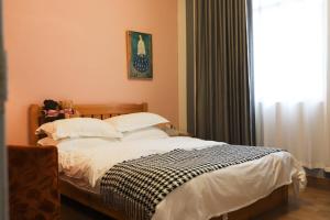 a bedroom with a bed with white sheets and a window at Changsha Fuxiangyuan International Hostel in Changsha