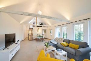 ein Wohnzimmer mit einem Sofa und einem TV in der Unterkunft Ferienwohnung „Langer Jammer“ im Hesterhoff in Bad Zwischenahn