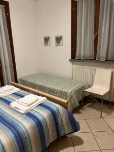 Habitación con 2 camas individuales y silla en Apartment Orio, en Orio al Serio
