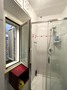 uma casa de banho com um chuveiro e uma porta de vidro em La casa di Judy e Frank em Tarquinia