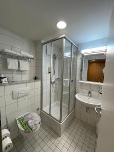 a bathroom with a shower and a toilet and a sink at Parkhotel Marzahn in Berlin