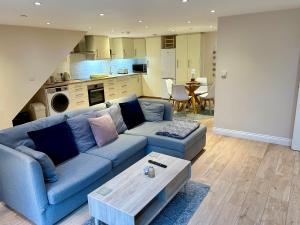 sala de estar con sofá azul y cocina en The Workshop, Bridge House, en Laxey