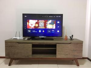 a flat screen tv sitting on top of a wooden entertainment center at Central, próximo ao HCAA e Calçadão in Santa Maria