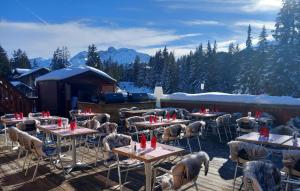 un grupo de mesas y sillas en un patio en Odalys Hotel New Solarium, en Courchevel