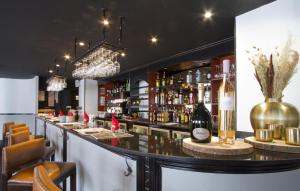 eine Bar mit einer Theke mit Weinflaschen in der Unterkunft Odalys Hotel New Solarium in Courchevel + 38 Fotos