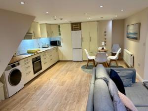 cocina y sala de estar con sofá y mesa en The Workshop, Bridge House, en Laxey