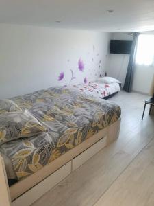 a bedroom with a bed with a comforter at Gîtes aux cœurs des vignes a 10mm du zoo de beauval 3 étoiles in Mareuil-sur-Cher