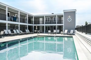 a pool at a hotel with chairs and a building at Atlantic Oceanfront Hotel, Wells Beach in Wells