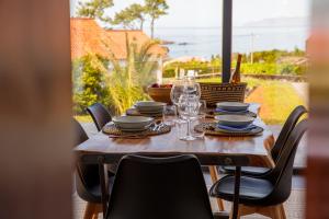a wooden table with glasses and plates on it at Cabanas do Pico 1A in Canto da Areia
