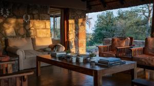 a living room with a table and a couch and chairs at Shalimpo Safari Home in Lentswelemoriti