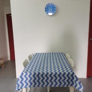 Una mesa con un reloj azul en una pared blanca. en Homestay Cik Tein Kuala Terengganu, en Kuala Terengganu 17 fotos más