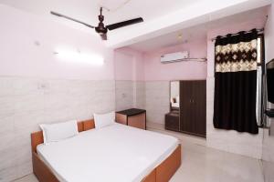 a bedroom with a white bed and a window at Hotel Kshama in Jabalpur