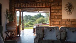 - un salon avec un canapé et une porte ouverte dans l'établissement Shalimpo Safari Home - Mashatu Game Reserve, à Lentswelemoriti 14 autres photos