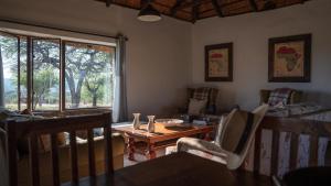 un salon avec une table et des chaises et une fenêtre dans l'établissement Shalimpo Safari Home - Mashatu Game Reserve, à Lentswelemoriti