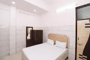 1 dormitorio con 1 cama y TV. en Hotel Kshama, en Jabalpur