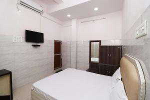 a bedroom with a bed and a tv on the wall at Hotel Kshama in Jabalpur