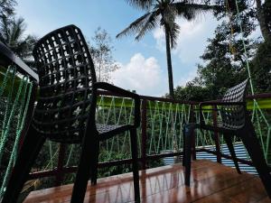 een paar stoelen op een terras bij Raymond's Holiday Homes in Vythiri