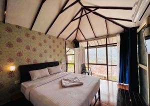 1 dormitorio con 1 cama con albornoz en Raymond's Holiday Homes, en Vythiri